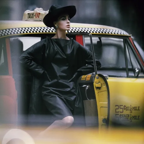 A woman next to a taxi.